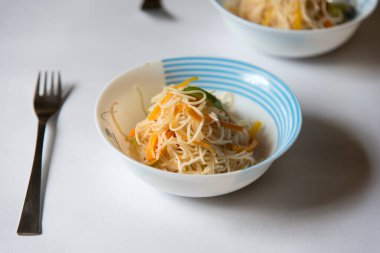 Arka planda bir kasede servis edilen kızarmış şehriye. Üst görünüm, seçici odak.