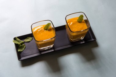 Mango smoothie ya da beyaz arka planda camda sallan. Üst görünüm, seçici odak.