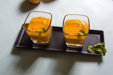 Taze mango smoothie ya da beyaz bir arka planda cam içinde salla. Üst görünüm, seçici odak.