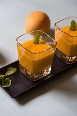 Taze mango smoothie ya da beyaz bir arka planda cam içinde salla. Üst görünüm, seçici odak.