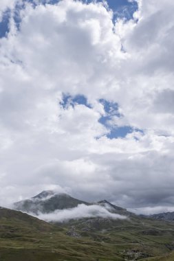 Bulutlu bir yaz gününde yüksek dağ manzarası. Dağların tepesini çevreleyen birkaç alçak dağ. Formigal, Huesca, İspanya.