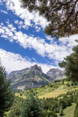 Bir yaz günü, pamuklu bulutlarla kaplı bir gökyüzü, Pena Telera, Valle de Tena, Biescas, Huesca, İspanya, dikey