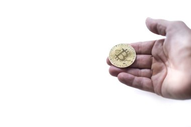 Bir kriptoyu ödeme formu olarak alabilecek ya da kabul edebilecek bir konumda olan bozuk parayı tutan bir el, beyaz arka plan, madeni para üzerine seçici odaklanma, kopyalama alanı