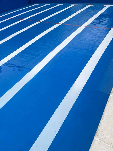 lines of the bottom of a half filled blue pool with a composition with the lines of the roads vanishing point, vertical