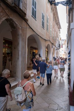 Ciudadela, Menorca İspanya; 4 Temmuz 2022: Ciudadelala, Menorca, Islas Baleares, İspanya 'nın tarihi merkezinde, alışveriş merkezleri ve butiklerle dolu kalabalık dar bir cadde.