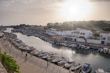 Akdeniz 'de bir marinada gün batımı, yukarıdan görülen tekne ve yatlarla birlikte deniz kıyısında, Ciudadela, Menorca, Balearic Adaları, İspanya' nın yatay limanında.