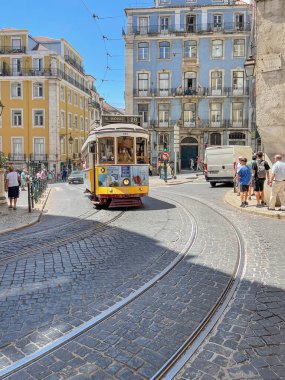 Lisbon, Portugal; august 8 2022:   the 28 number tramway running through the streets of the historic center of Lisbon full of tourists, vertical