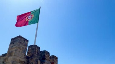 flag of portugal waving in the wind on a clear sky day from the battlements of St Georges castle in Lisbon, Portugal, 4k