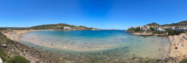 Akdeniz, Fornellls plajları, Menorca, Balear Adaları, İspanya 'da yıkanan turistlerle dolu bir yaz gününde Cala Tirant' ın panoramik manzarası
