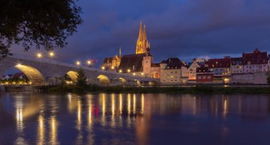 Regensburg 'de. Tuna Nehri üzerindeki eski taş köprü Gece ışığında.
