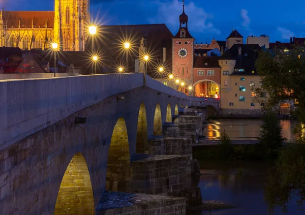 Regensburg. Ponte de pedra velha sobre o rio Danúbio na luz da noite. — Fotografia de Stock
