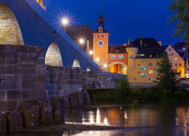 Gündoğumunda Tuna Nehri üzerindeki eski ortaçağ taş köprüsü. Regensburg 'de. Almanya. Bavyera.