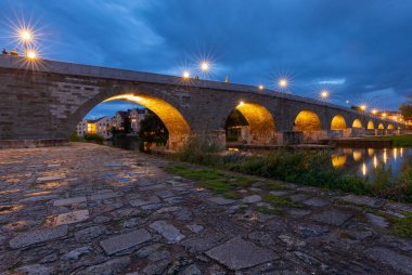 Gündoğumunda Tuna Nehri üzerindeki eski ortaçağ taş köprüsü. Regensburg 'de. Almanya. Bavyera.