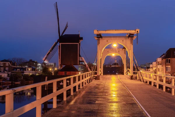 Een oude houten molen aan de oever van een kanaal in Leiden bij zonsopgang. — Stockfoto