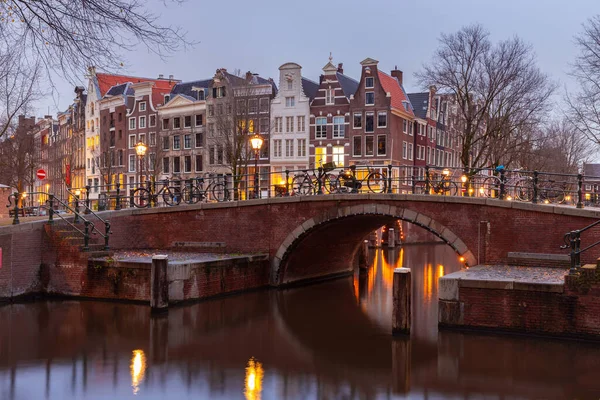 A picturesque view of the city embankment and facades of medieval fairy houses at sunset. Amsterdam. Netherlands.