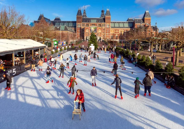 Peoples skating on an ice rink with the Rijksmuseum in the background. — Stockfoto