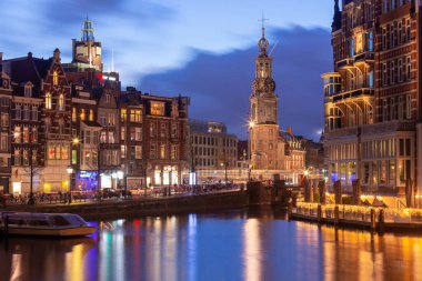 Gün batımında Amsterdam 'ın rıhtımındaki güzel eski evler.