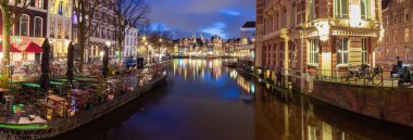 Gün batımında Amsterdam 'ın rıhtımındaki güzel eski evler.