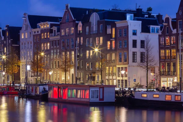 Beautiful old houses on the city waterfront of Amsterdam at sunset. — Stock Photo, Image