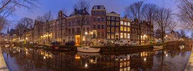 Gün batımında şehrin panoramik manzarası ve evlerin cepheleri. Amsterdam mı? Hollanda.