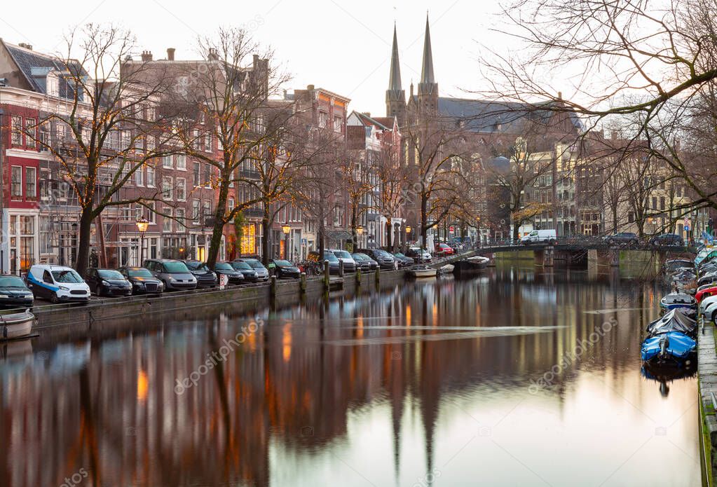 Picturesque view of the city embankment and the facades of medieval fairy-tale houses at dawn. Amsterdam. Netherlands.