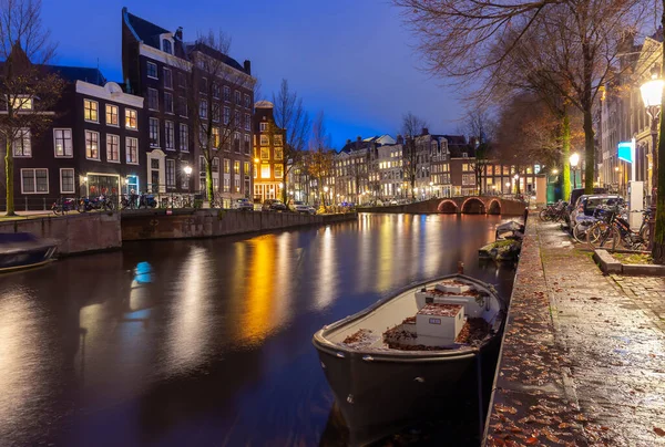 Mooie oude huizen aan de stadswaterkant van Amsterdam bij zonsondergang. — Stockfoto