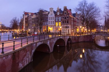 Gün batımında Amsterdam 'ın rıhtımındaki güzel eski evler.
