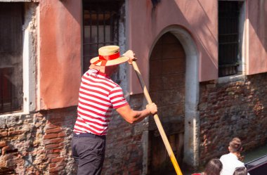 Venedik. Güneşli bir sabahta geleneksel gondolda gondolcu..