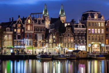 Gün batımında Amsterdam 'ın rıhtımındaki güzel eski evler.