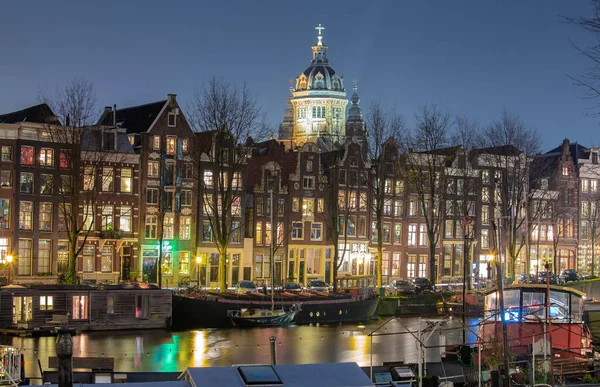 Mooie oude huizen aan de stadswaterkant van Amsterdam bij zonsondergang. — Stockfoto