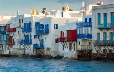 Güneşli bir sabahta, Mykonos adasının rıhtımındaki eski beyaz geleneksel evler. Yunanistan.