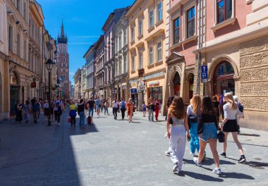 Krakow, Polonya - 18 Temmuz 2022: Güneşli bir günde eski şehir sokaklarında turist grupları.
