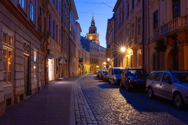 Facades of old houses on the central street of the city at dawn. Krakow. Poland.