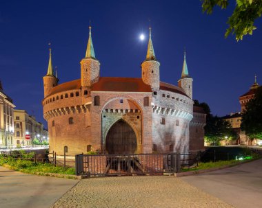 Stone building of the Barbican Fort in Krakow in the night illumination at dawn. Poland.