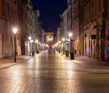 Facades of old houses on the central street of the city at dawn. Krakow. Poland.