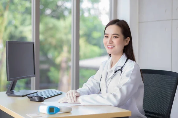 Asiático Profesional Joven Sonriente Mujer Médico Sentado Mirar Hacia Adelante — Foto de Stock