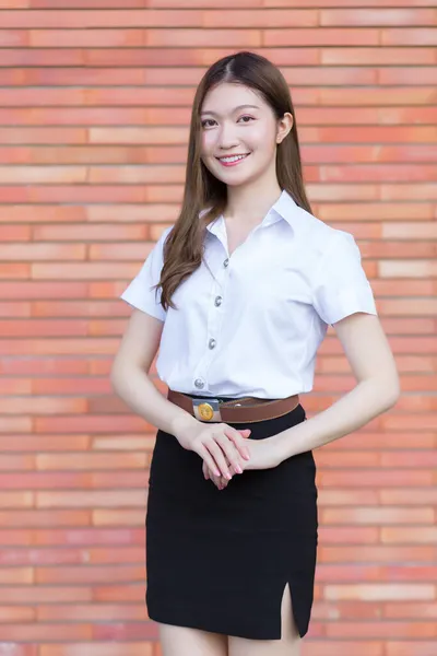 一个穿着大学生制服的泰国成人学生的画像 站在砖头背景上 胳膊交叉着的亚洲美女 — 图库照片