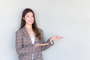 Siyah uzun saçlı, ekose elbise giyen ve kameraya gülümseyen Asyalı profesyonel bir kadın beyaz arka planda mevcut üründür..