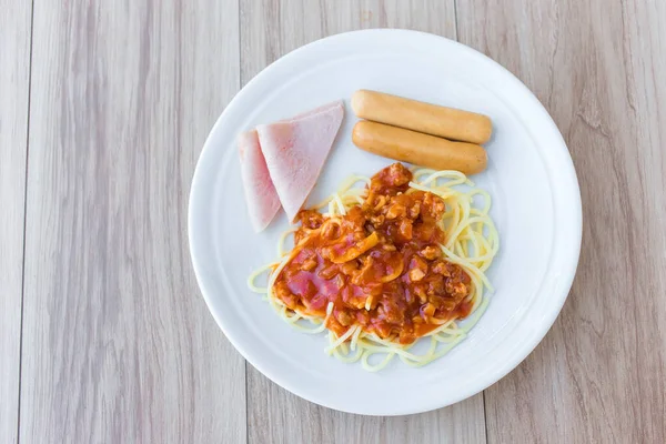 配上番茄酱的意大利面配上煮熟的火腿和猪肉香肠 作为美国人的早餐餐 放在白盘上 — 图库照片