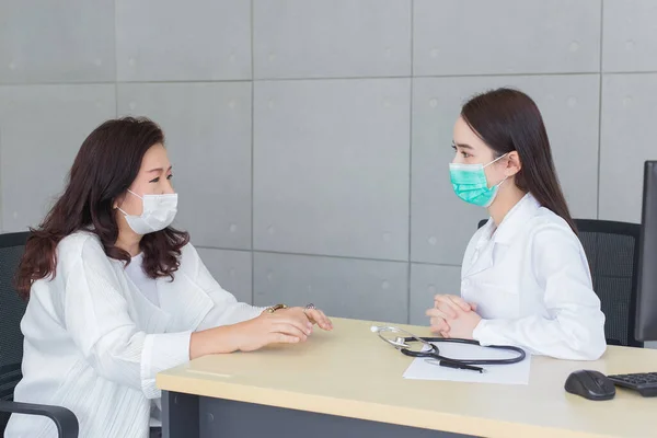 専門的なアジアの医師の女性は 彼女は医療で病院で医療面マスクを身に着けている間 彼女の患者と話します 汚染Pm2 新しい通常とコロナウイルス保護の概念 — ストック写真