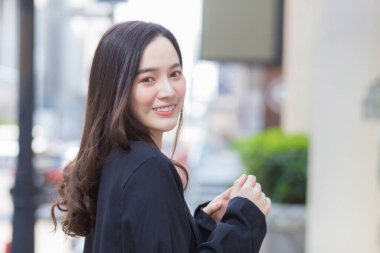 Genç, şık hippi işinin portresi güzel Asyalı kadın sokakta yürüyor, şık kıyafetler giyiyor, arkasını dönüyor ve kışın düşünceli görünüyor..