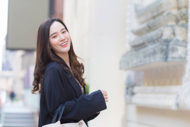 Genç, şık hippi işi portresi güzel Asyalı kadın sokakta yürüyor, şık kıyafetler giyiyor, arkasını dönüyor ve kışın düşünceli görünüyor..