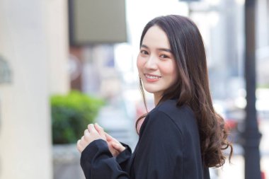 Genç, şık hippi işinin portresi güzel Asyalı kadın sokakta yürüyor, şık kıyafetler giyiyor, arkasını dönüyor ve kışın düşünceli görünüyor..