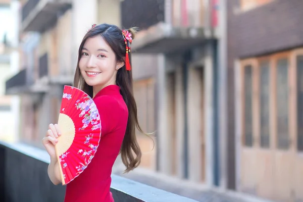Hermosa Mujer Asiática Puestos Vestido Rojo Sostiene Ventilador Entre Centro —  Fotos de Stock