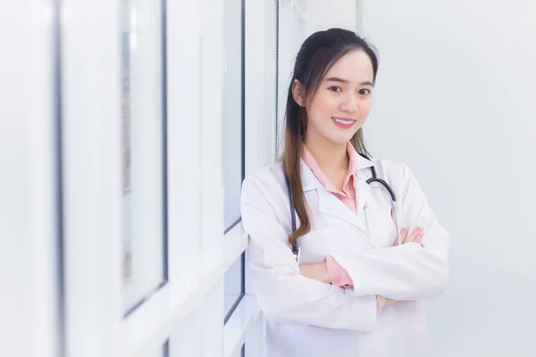 专业的亚洲女医生 身穿白色的实验室外套和听诊器 她站在医院的办公室里交叉着双臂 — 图库照片