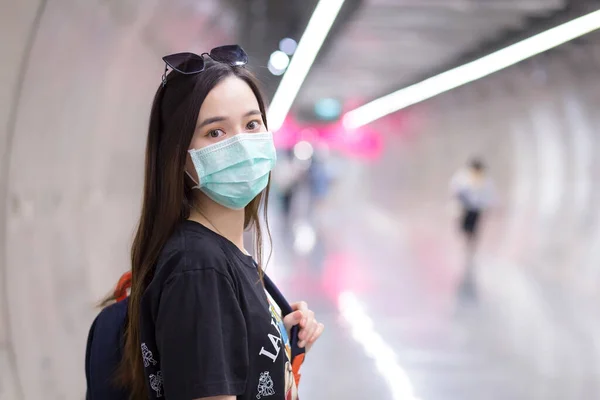 亚洲美女穿着黑色衬衫 戴着医疗面罩走进地铁隧道 手里拿着背包 医疗保健 污染Pm2 5和新的正常概念 — 图库照片