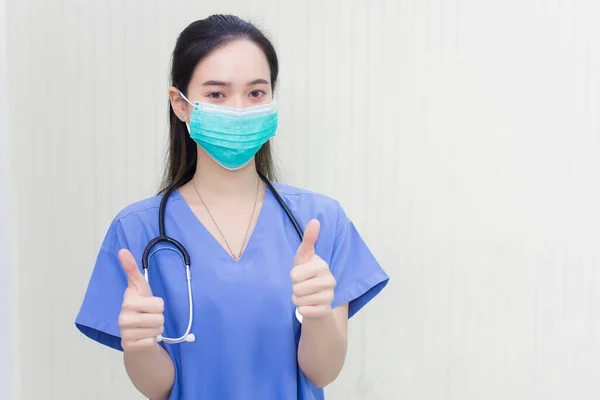 医療用マスクをした若いアジア系女性医師が白地に手を振っている 彼女は 医療や新しい通常の概念で彼女の呼吸器系 Covid を保護するためのマスクを身に着けています — ストック写真