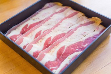 Beef bacon brisket is fresh beef raw sliced was served for Sukiyaki ,Korean grilled beef and Shabu or Yakiniku restaurant which it put on black plate.