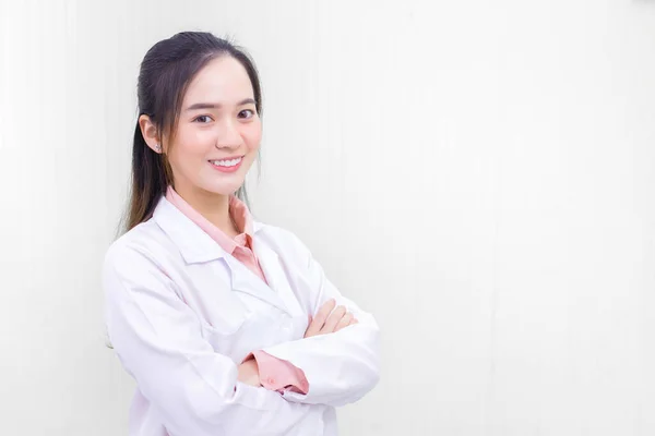 黒い長い髪をしているアジアの女性医師は ヘルスケアの病院のオフィスルームで腕のクロスながら 一様として聴診器と白いラボのコートを身に着けている 新しい通常とコロナウイルス保護の概念 — ストック写真