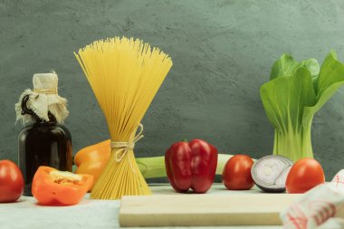 Sebzeli, kuru ve peynirli makarna. Ahşap arka planda kurutulmuş makarna seçimi. Boşluğu kopyala